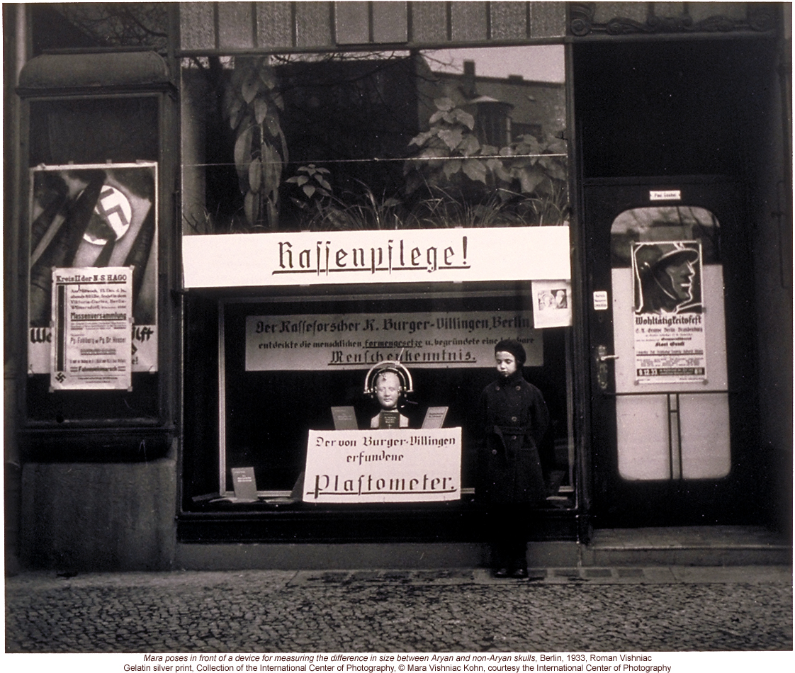 Nazi propaganda in Berlin storefront, including anthropometric device for measuring differences between Aryan & Non-Aryan skulls (by Roman Vishniac)