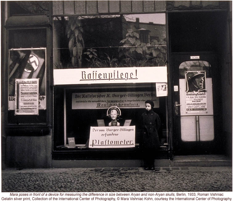 Nazi propaganda in Berlin storefront, including anthropometric device for measuring differences between Aryan & Non-Aryan skulls (by Roman Vishniac)